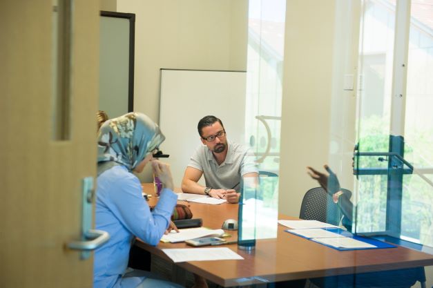 Three people working in a conference room.