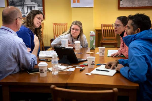 four professors having a discussion with a student