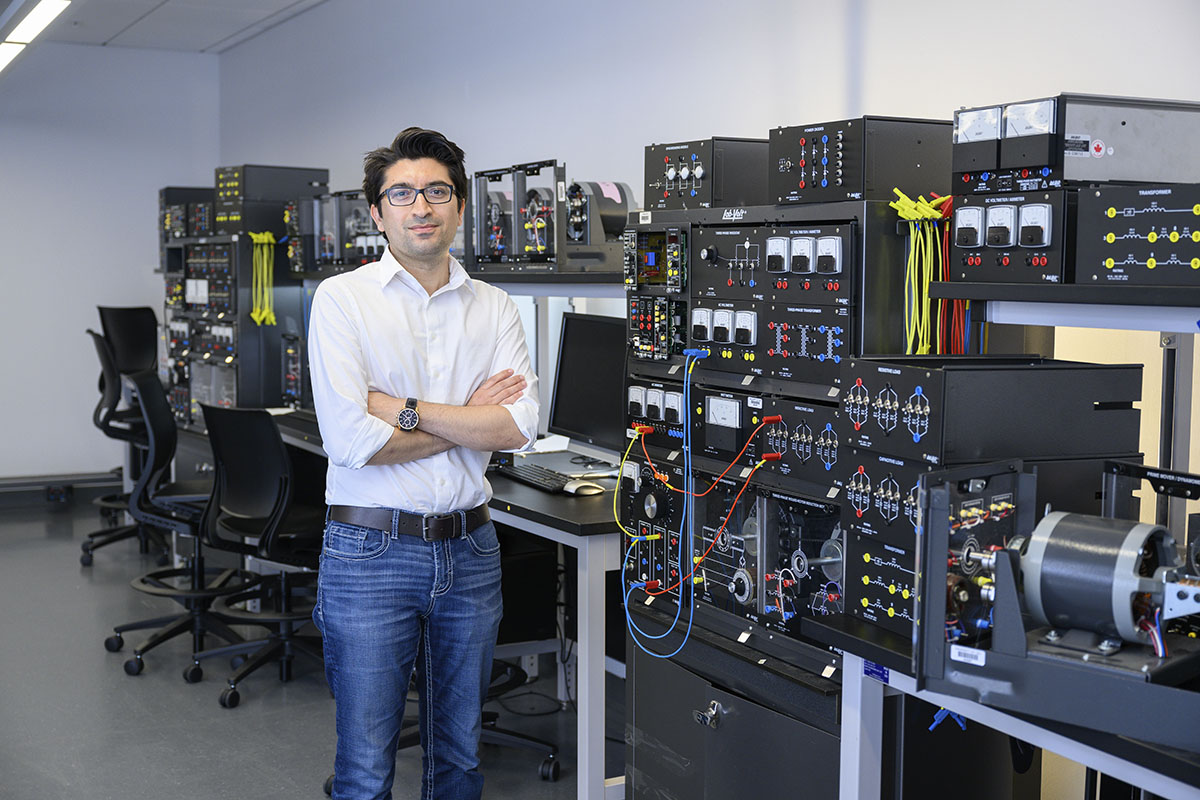 Picture of Mehdi Farasat standing in front of computers